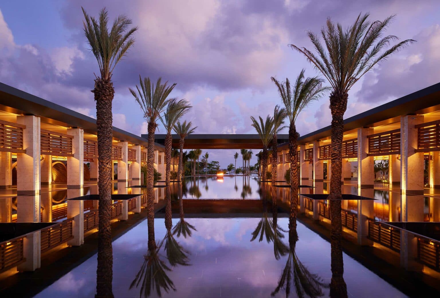 Palm-lined court with a reflective pool at dusk