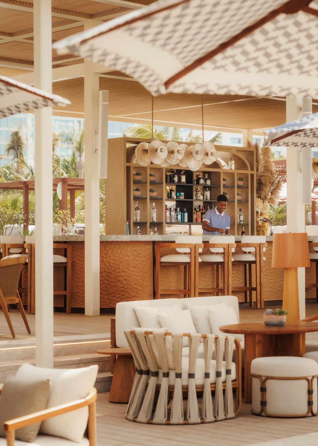 Covered beach bar with stools and white parasols