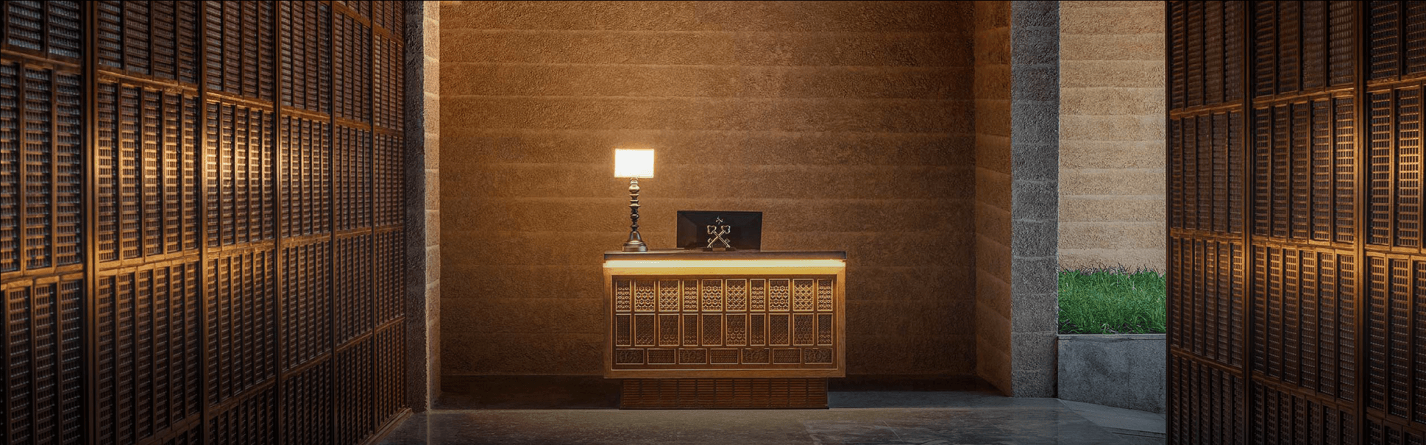 Warmly lit entrance console with a table lamp against a textured feature wall