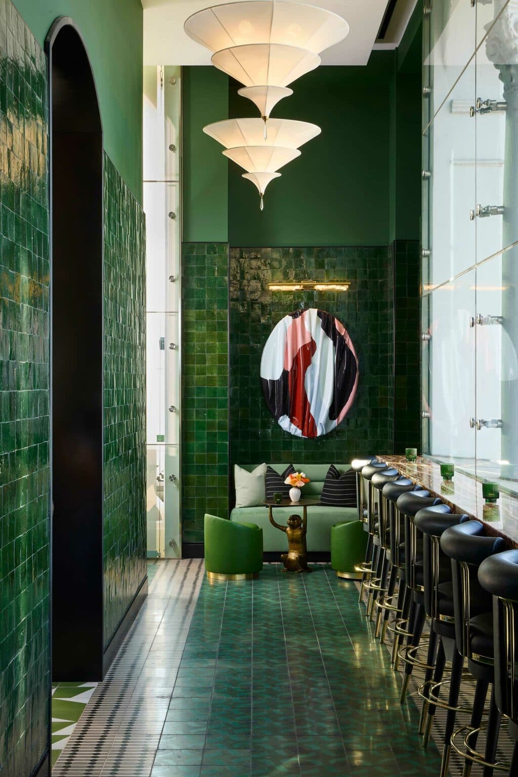 Lounge with deep green feature wall, cushioned seating and layered lighting